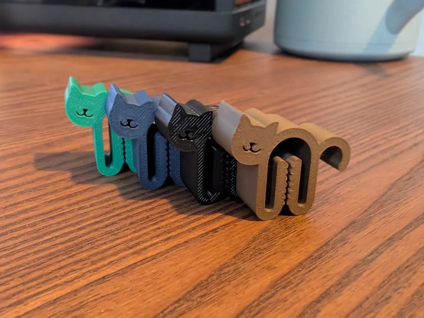 Row of colourful cat-shaped bag clips on a wooden table